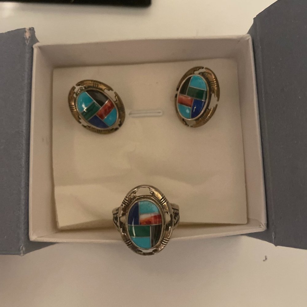 A vintage jewelry set includes, earrings, brackets and a ring.